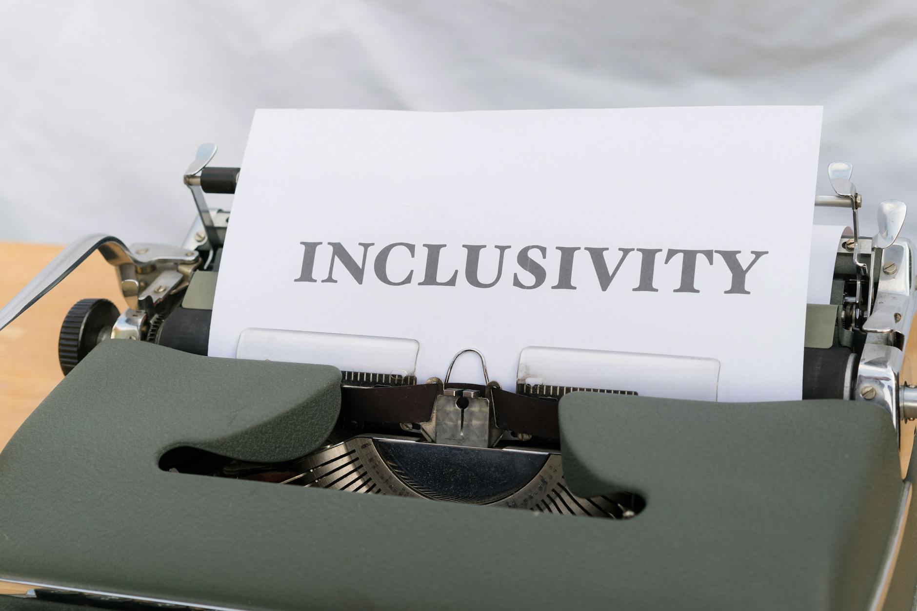 Close-up of a vintage typewriter printing the message 'INCLUSIVITY' on paper.