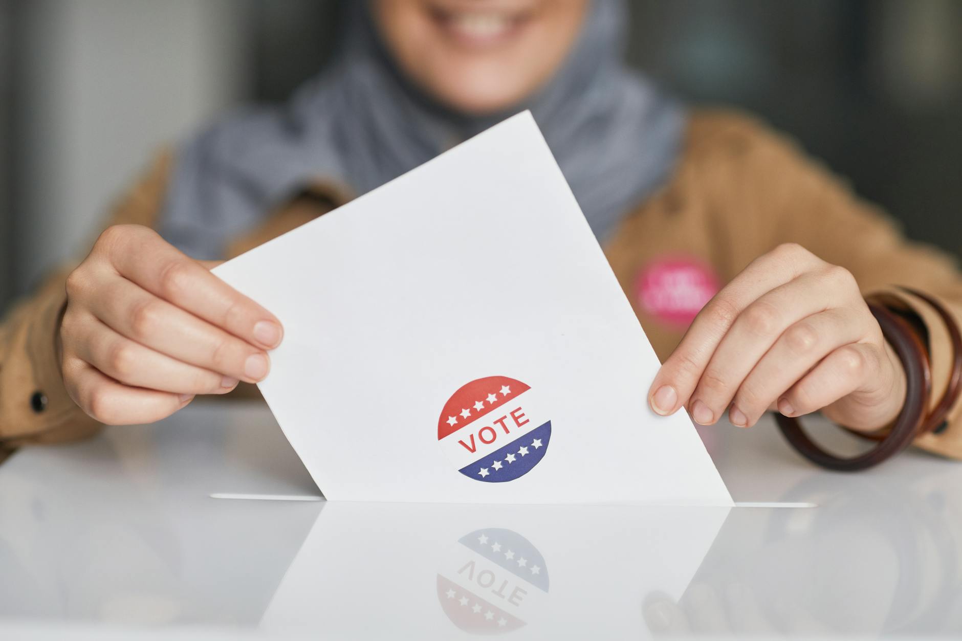 Close-up of hands holding a vote ballot, symbolizing election participation.